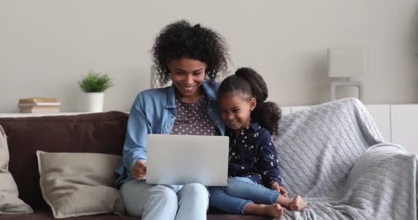 Africano madre 5s figlia ridere mentre guarda cartoni animati su computer portatile — Video Stock