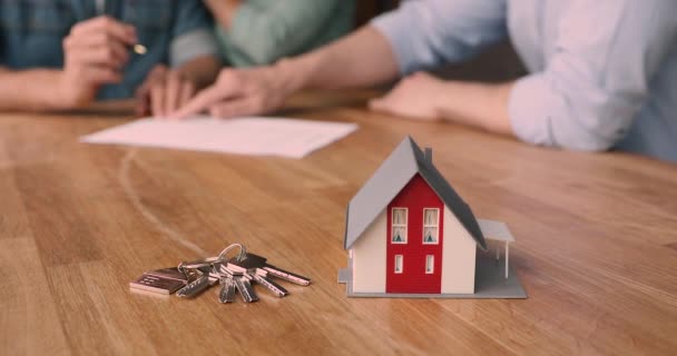 Pár tvorby dohoda, klíče a dům model na stole — Stock video