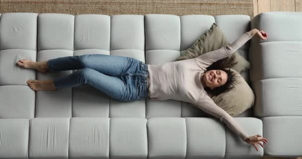 Über volle Länge Ansicht friedliche Frau Stretching auf gemütlichen Sofa — Stockvideo