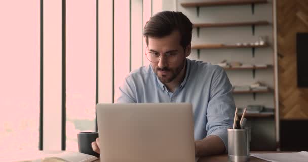 高価なビジネスマンは、ノートパソコンでテーブルの熟考のアイデアのテキストメッセージに座る — ストック動画