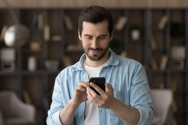 Fechar o homem satisfeito usando telefone, olhando para a tela — Fotografia de Stock