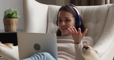 Kadın bilgisayarında video çağrı uygulamasını kullanarak arkadaşıyla uzaktan sohbet ediyor.