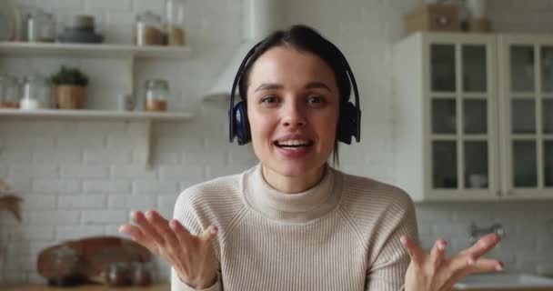 Livlig ung kvinna bär trådlösa hörlurar leda videokonferens konversation — Stockvideo