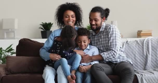 Padres africanos cosquillas niños pequeños disfrutan de tiempo de juego en casa — Vídeos de Stock