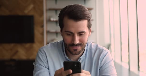 Podnikatel sedí v kanceláři drží smartphone pomocí mobilní obchodní aplikace — Stock video