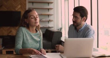 Danışman, kadın stajyere ofisinde evrak işlerinde yardımcı olur.