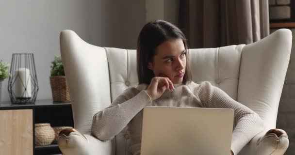 Приваблива жінка оселилася на стільці смс на ноутбуці — стокове відео