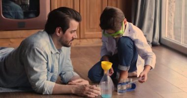 Baba ve küçük oğlu mutfakta kimya deneyleri yapıyor.