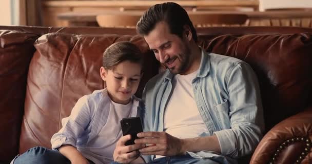 Pequeño hijo y papá se divierten con la aplicación móvil smartphone — Vídeos de Stock