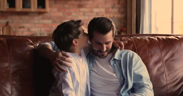 Little boy embrace father whispers in his ear a secret — Stock Video