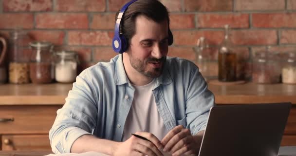 Hombre usar auriculares hablar con el tutor de idioma extranjero por videocall — Vídeo de stock