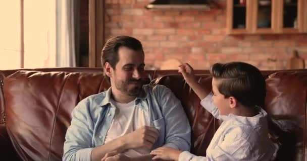 Überglücklicher junger Vater kitzelt kleinen fröhlichen Sohn — Stockvideo