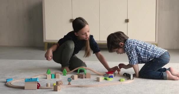 집에 세워 놓은 장난감 철 도 놀이를 하는 친형제 자매들 — 비디오
