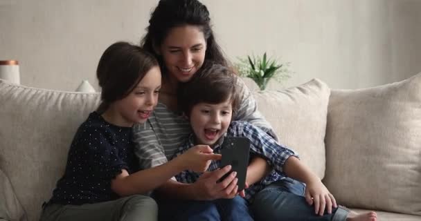 Laughing family have fun use cool mobile application on cellphone — Stock Video