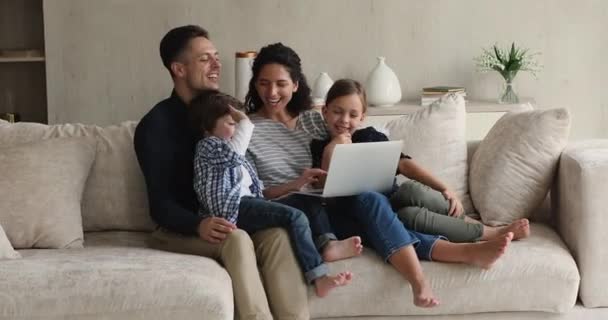 Щаслива сім'я сидить на дивані, використовуючи ноутбук, роблячи відеодзвінки — стокове відео