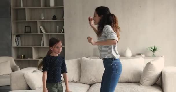 Happy mother little daughter listen music fooling dancing at home — Stock Video