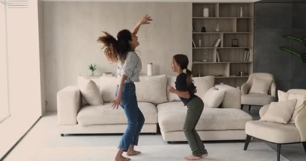 Ung lycklig mor liten dotter dansar i vardagsrummet — Stockvideo