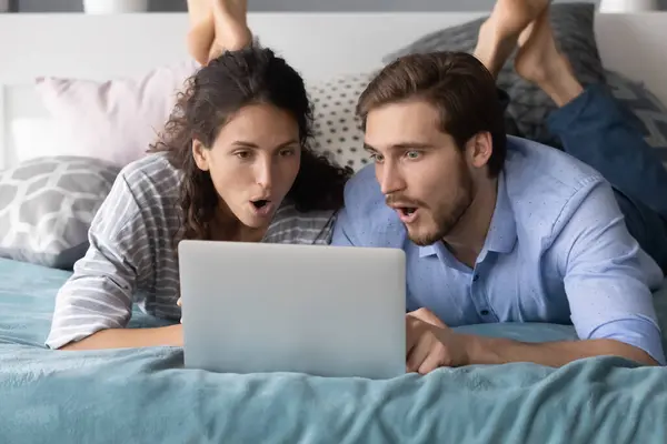 Έκπληκτο ζευγάρι σοκαρισμένο από τα online νέα στο laptop — Φωτογραφία Αρχείου