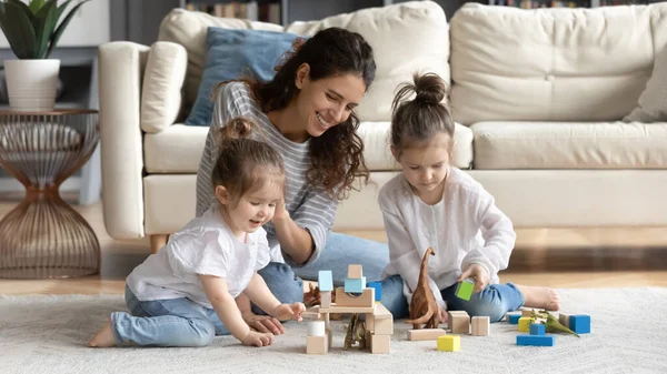 Pečující šťastná maminka hrát s malými dcerami — Stock fotografie
