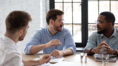 Çeşitli ekip proje stratejisi, satış ve pazarlama raporlarını tartışıyor