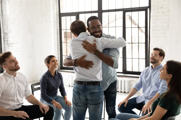 Diversos amigos de la comunidad de apoyo abrazándose a la reunión de terapia — Foto de Stock