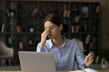 Bin yıllık kadın çalışanın gözlüğünü çıkarması göz ağrısına neden oluyor.