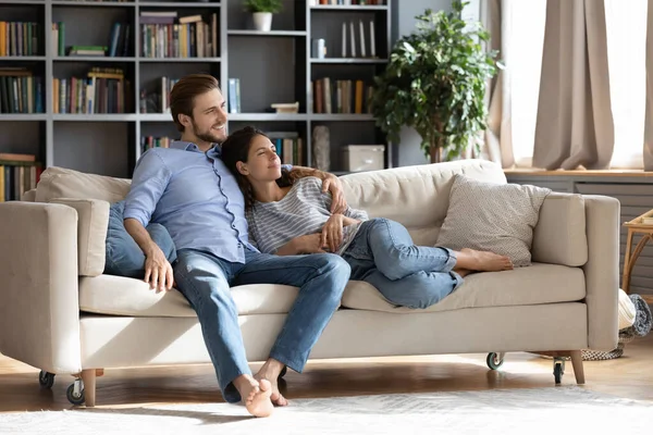 Счастливая пара отдыхает на диване мечтая визуализации — стоковое фото