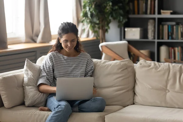 Glückliche junge Frau arbeitet online am Laptop — Stockfoto