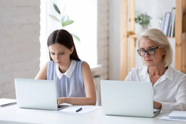 Różnorodne pracownice pracują na laptopach w biurze — Zdjęcie stockowe