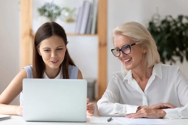 Smiling female employees work on laptop in office — Stock Photo, Image
