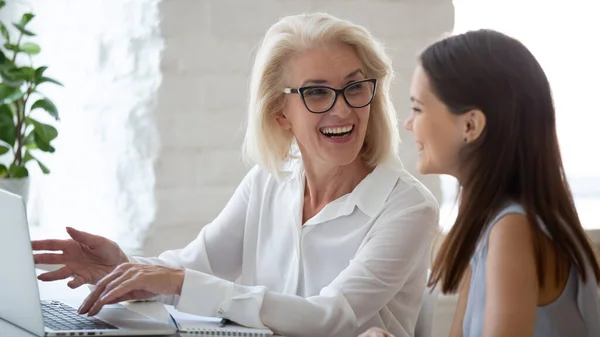 Lächelnde Kolleginnen beim Brainstorming am Laptop — Stockfoto