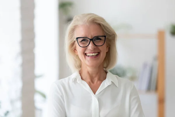 Retrato en la cabeza de la sonriente mujer de negocios senior en el cargo —  Fotos de Stock