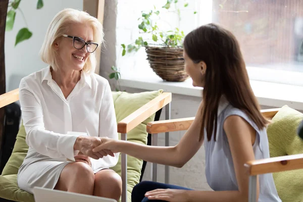 Smiling female colleagues handshake at business meeting — Stock Photo, Image