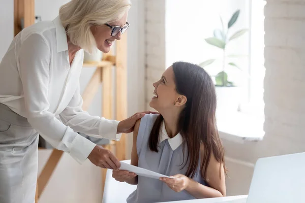 Happy businesswoman congratulate smiling female employee with promotion — Stock Photo, Image