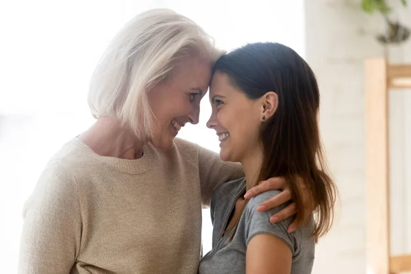 Sorridente anziano mamma abbraccio adulto giovanissima figlia — Foto Stock