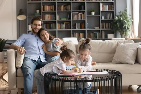 Gelukkig jong gezin met kinderen ontspannen in de woonkamer — Stockfoto