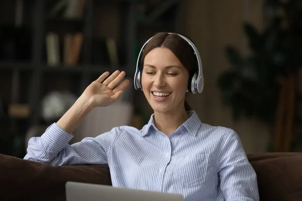 Teen female in earphones participate in videoconference raise hand hello — Stock Photo, Image