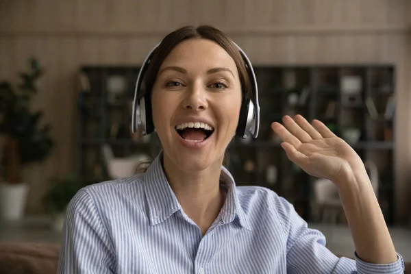 Active female blogger in headphones look at camera greet audience — Stock Photo, Image