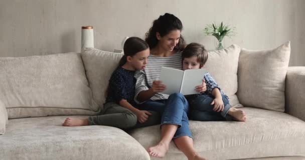 Madre cariñosa leyendo un libro de cuentos de hadas a niños pequeños — Vídeos de Stock