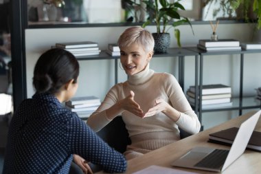 Gülümseyen çok ırklı iş kadını dizüstü bilgisayarda birlikte çalışıyor