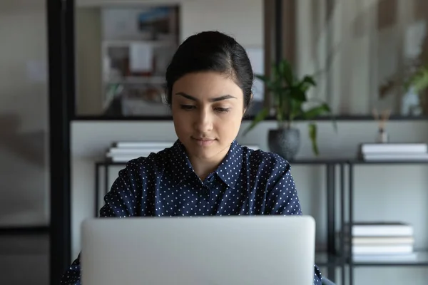 Jonge Indiase vrouw werken online op laptop in het kantoor — Stockfoto