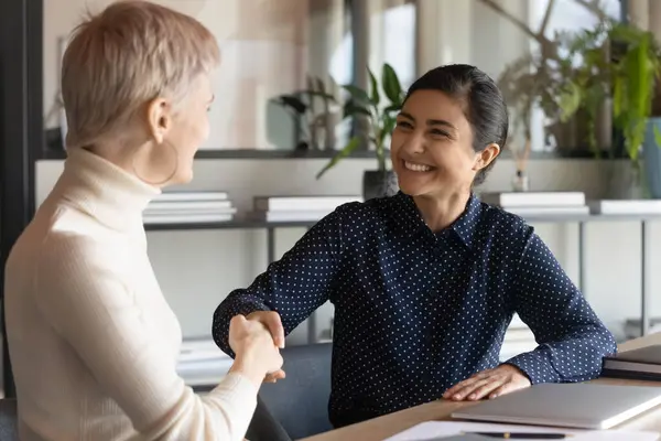 Des employés multiraciaux souriants se serrent la main lors d'une réunion de bureau — Photo