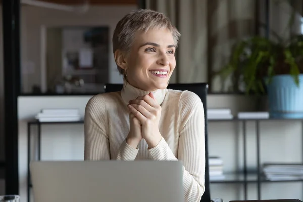 Smiling businesswoman work on laptop looking in distance — Stock Photo, Image