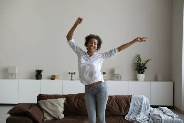 Gelukkig jong Afrikaans amerikaans vrouw dansen in woonkamer. — Stockfoto