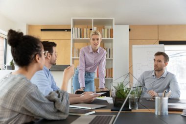 Takım lideri olan çeşitli çalışanlar brifinge katılıp projeyi tartışıyorlar.