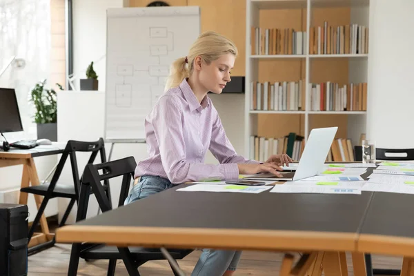 Vista laterale donna d'affari fiduciosa che lavora sul computer portatile in ufficio — Foto Stock