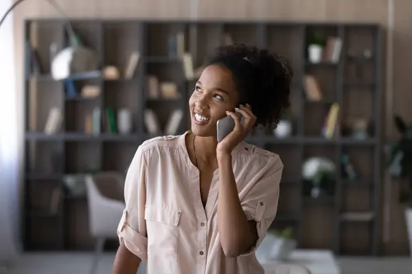 Dreamy happy young african ethnicity woman holding mobile phone call. — Stock Photo, Image