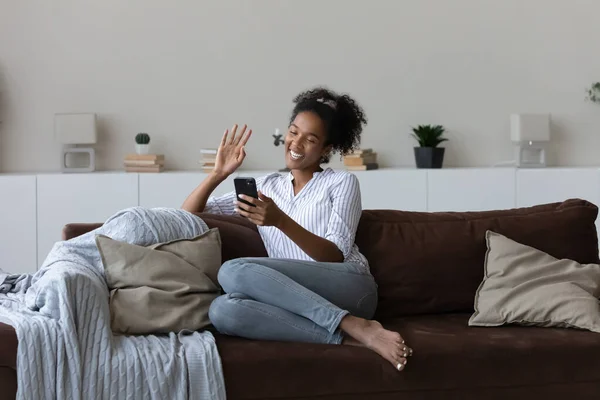 Happy millennial african woman holding web camera mobile video call.