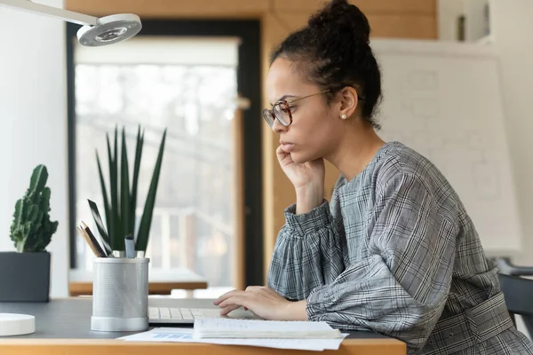 Крупный план афроамериканской бизнесвумен в очках с помощью ноутбука — стоковое фото
