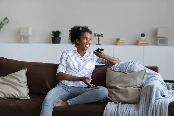 Gelukkig jong gemengd ras afrikaanse vrouw opname audio bericht. — Stockfoto